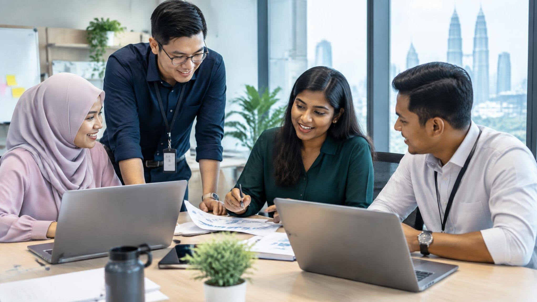 Diverse Malaysian professionals collaborating in a modern office meeting